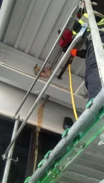Operator managing diamond core drill rig on elevated metal scaffolding platform