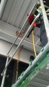 Operator managing diamond core drill rig on elevated metal scaffolding platform
